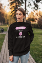 Load image into Gallery viewer, Discover our women's relaxed fit sweatshirt featuring the inspiring slogan 'Live in the Present.' This fashionable oversized sweatshirt offers ultimate comfort, making it the perfect addition to your casual wardrobe. Embrace effortless style and stay cosy while promoting a positive mindset. Upgrade your collection today!
