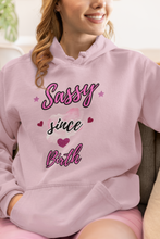 Load image into Gallery viewer, Person wearing a pink hoodie with 'Sassy since birth' text