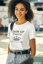 Load image into Gallery viewer, Discover the perfect blend of style and sustainability with our organic t-shirt featuring the empowering slogan 'Chin Up Princess, or the Crown Slips'. Crafted from eco-friendly materials, this shirt is designed to inspire confidence and grace, while offering comfort and durability.