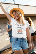 Load image into Gallery viewer, Embrace your wanderlust with this retro-inspired 'Just a Girl Who Loves to Travel' graphic t-shirt, designed for adventurous souls. Whether you're jet-setting to a new destination or dreaming of your next journey, this iconic design adds a timeless touch to your wardrobe. A must-have women's tee for travel lovers!