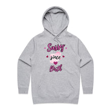 Load image into Gallery viewer, Own your sass with the ‘Sassy Since Birth’ pocket hoodie – featuring a bold graphic design and cosy cotton blend. Perfect for comfort with attitude.
