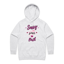 Load image into Gallery viewer, Own your sass with the ‘Sassy Since Birth’ pocket hoodie – featuring a bold graphic design and cosy cotton blend. Perfect for comfort with attitude.
